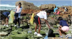  ?? PICTURE: TRACEY ADAMS/AFRICAN NEWS AGENCY(ANA) ?? CLEAN-UP CREW: Young volunteers (foreground, from left) Tyler Juries, 13, Quanita Banoo, 14, Akeela Basheer, 13, and Tatum Geduld, 12, help clean up the rocky shore at Muizenberg.