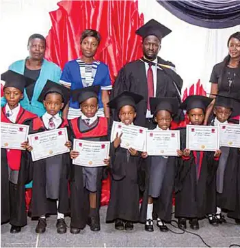  ??  ?? CATCH THEM YOUNG. .. ECD graduates display their certificat­es at a graduation ceremony at Oakdale Group of Schools on Monday last week. Behind them are their teachers