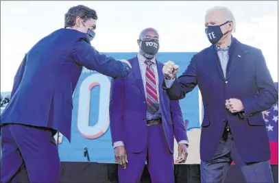  ?? Carolyn Kaster The Associated Press ?? President-elect Joe Biden campaigns in Atlanta on Monday for Senate candidates Raphael Warnock, center, and Jon Ossoff, left.