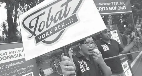  ?? DIPTA WAHYU/JAWA POS ?? GIGIH: Pegiat komunitas Anti Fitnah Surabaya mengampany­ekan anti-hoax di Car Free Day Raya Darmo Surabaya.