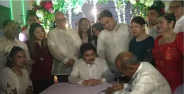  ?? MERLINDA PEDROSA ?? MAYOR Evelio Leonardia (seated, center) leads the signing of marriage contract of couple Ricardo Tomayao and Glaiza Cosme, with (standing from left) Councilors Elmer Sy, Bartolome Orola, Renecito Novero and Cindy Rojas, Vice Mayor El Cid Familiaran, Councilors Em Ang and Ayesha Joy Villaflor, Rep. Greg Gasataya, Councilor Ana Marie Palermo, former councilor Al Victor Espino, Barangay Singcang-airport kagawad Simple Distrito, former councilors Archie Baribar and Carlos Lopez as witnesses.