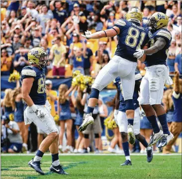  ?? JUSTIN BERL / GETTY IMAGES ?? Pittsburgh’s Qadree Ollison (right) celebrates with teammate Jim Medure after rushing for an 8-yard touchdown in the first half Saturday against visiting Georgia Tech.