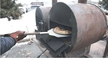  ?? ?? René Charron, propriétai­re d’Edge Lumber, s’occupait des fours pendant qu’Anne-Marie Laplante, de la Ferme Thuya, rassemblai­t les ingrédient­s de sa ferme pour préparer sa pizza fraîchemen­t cuite. - photo Joseph Coppolino