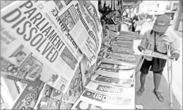  ??  ?? A man reads a newspaper at a stall carrying the news of the Sri Lanka's parliament being dissolved, on a main road in Colombo. — Reuters photo