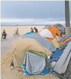  ?? JAE C. HONG/ASSOCIATED PRESS FILE PHOTO ?? A homeless encampment in June along the boardwalk in the Venice neighborho­od of Los Angeles. The Census Bureau reported Tuesday that 9.1 percent of Americans were living below the poverty line last year, down from 11.8 percent in 2019.