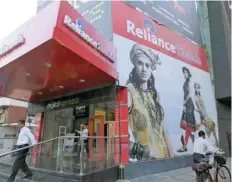  ?? — Reuters ?? People are seen outside Reliance Trends store in New Delhi.