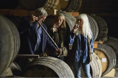  ??  ?? ABOVE Julian, Matilda and Diana Temperley sample a Burrow Hill cider aged in an oak barrel