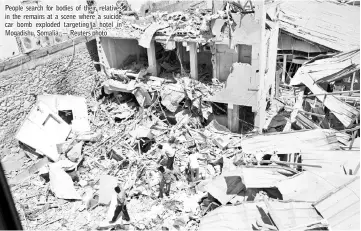  ??  ?? People search for bodies of their relatives in the remains at a scene where a suicide car bomb exploded targeting a hotel in Mogadishu, Somalia. — Reuters photo