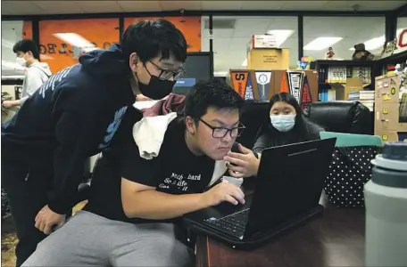  ?? Carolyn Cole Los Angeles Times ?? KENJI HORIGOME, center, Nicholas Tran and Kristina Sanchez wait for college admissions emails at Downtown Magnets High School.