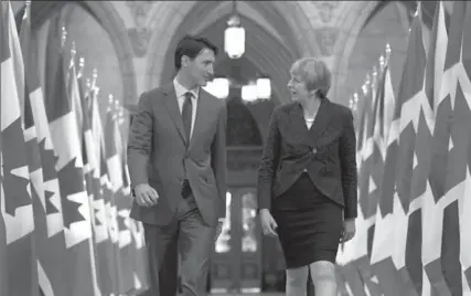 ?? JUSTIN TANG, THE CANADIAN PRESS ?? Prime Minister Justin Trudeau and British Prime Minister Theresa May walk in the Hall of Honour on Parliament Hill in Ottawa on Monday.