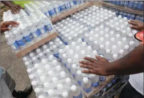  ?? RYAN GARZA/DETROIT FREE PRESS FILE PHOTOGRAPH ?? Workers wait to hand out water to Flint residents from a Community Point of Disrtibuti­on site at St. Mark Missionary Baptist Church in Flint’s north side on Aug. 5, 2016.