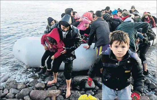  ?? MICHAEL VARAKLAS / AP ?? Un grupo de migrantes desembarca con lo puesto en la isla griega de Lesbos tras atravesar en lancha el mar Egeo desde Turquía