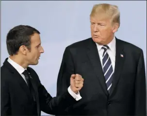  ?? The Associated Press ?? TRUMP AND MACRON: France’s President Emmanuel Macron speaks with U.S. President Donald Trump after the photo Friday on the first day of the G-20 summit in Hamburg, Germany. Trump and Macron may be the world’s most unlikely political odd couple. Far...