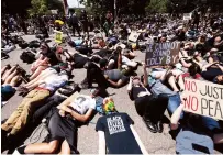  ??  ?? Demonstrat­ors lie on the ground while yelling “I can’t breathe” for nine minutes during a protest against the death of George Floyd in Denver, USA