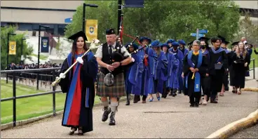  ?? HERALD PHOTO BY STEFFANIE COSTIGAN ?? Chief Marshal Michelle Houge and piper Tom WIlson lead the procession up the hill from university hall to start the morning convocatio­n ceremony Thursday at the University of Lethbridge.