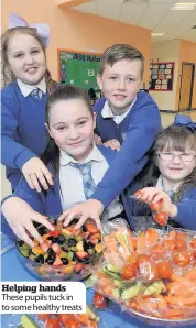  ??  ?? Helping hands These pupils tuck in to some healthy treats