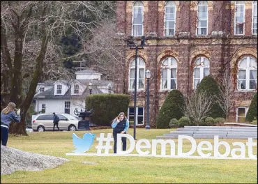  ?? AFP ?? A student poses with a sign advertisin­g the upcoming Democratic debate on the campus of Saint Anselm College in Manchester, New Hampshire.