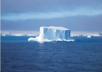  ?? PHOTOS: JUDY JOHNSON ?? Icebergs and floes dot the waters of Antarctica. This is called a tabletop iceberg for obvious reasons.