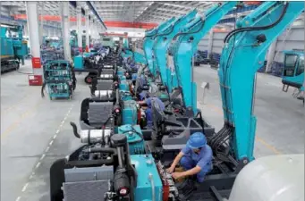  ?? LIA ZHU / CHINA DAILY ?? Workers on the assembly line at Sunward Intelligen­t Equipment Co Ltd.