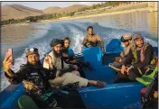  ?? (AP/Bernat Armangue) ?? Taliban fighters enjoy a boat ride Friday near the Qargha dam, on the outskirts of Kabul.