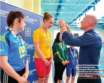  ?? Photo: Sam Barnes/Sportsfile ?? Paul O’Connell presents Cora Rooney from Donegal with the two gold medals for U14 swimming at the Aldi Community Games Festival