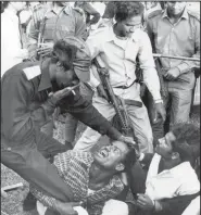  ?? (File Photo/AP/Horst Faas, Michel Laurent) ?? Bangladesh­i guerrillas beat a victim Dec. 18, 1971, as they torture and execute four men suspected of collaborat­ing with Pakistani militiamen accused of murder, rape and looting during months of civil war in Dacca, Bangladesh.