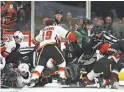  ?? ROSS D. FRANKLIN/ AP ?? Flames left wing Matthew Tkachuk (19) rushes over to battle Coyotes goaltender Darcy Kuemper (35) Saturday.