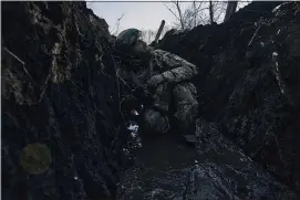  ?? LIBKOS — THE ASSOCIATED PRESS ?? A Ukrainian soldier takes cover in a trench under Russian shelling on the frontline close to Bakhmut, Donetsk region, Ukraine, on Sunday. The battle for Bakhmut could go either way this week.