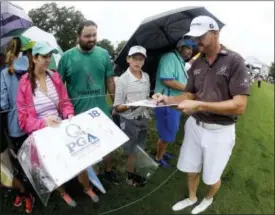  ?? CHRIS CARLSON — THE ASSOCIATED PRESS ?? Jimmy Walker signs autographs on the 18th hole during a practice round for the PGA Championsh­ip golf tournament at the Quail Hollow Club Tuesday in Charlotte, N.C. For the first time, the PGA Championsh­ip is letting players wear shorts in practice...