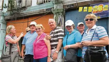  ??  ?? Victor ( second from right, background) and members of his family visiting Raub in 2011. Victor’s cousin, susan Thomas ( left), a granddaugh­ter of Harry Thomas Bibby, William’s second eldest son, is pointing at an old street sign, Bibby Road, nailed to...