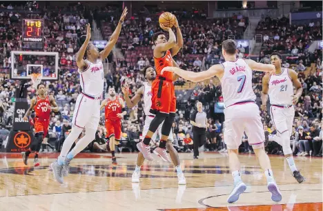  ?? MARK BLINCH/THE CANADIAN PRESS ?? Toronto Raptors guard Kyle Lowry puts up a shot against Miami Heat players, from left, Josh Richardson, Goran Dragic, and Hassan Whiteside on Tuesday in a 115-112 Toronto victory that saw Lowry score 22 points and fellow NBA all-star DeMar DeRozan...