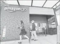  ?? Associated Press ?? People walk past an Amazon Go store, currently open only to Amazon employees, in Seattle, on April 27.