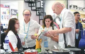  ?? XINHUA ?? Merchants discuss business deals at the 124th session of the Canton Fair in Guangzhou, capital of Guangdong province, on Oct 23.