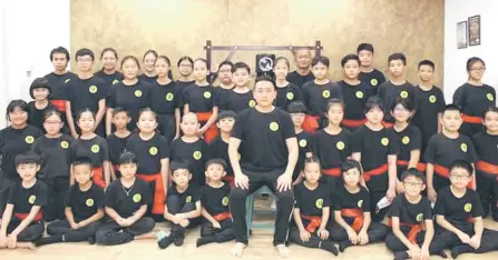  ?? ?? Chai (seated) with his students who participat­ed in the Singapore Internatio­nal Wudebei Traditiona­l Martial Arts Tournament.