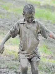  ??  ?? I think I got a bit muddy...a young runner checks out the day’s result.