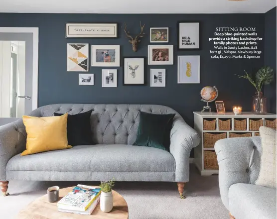  ??  ?? SITTING ROOM Deep blue-painted walls provide a striking backdrop for family photos and prints. Walls in Sooty Lashes, £28 for 2.5L, Valspar. Newbury large sofa, £1,299, Marks & Spencer