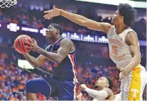  ?? AP PHOTO/MARK HUMPHREY ?? Tennessee’s Derrick Walker Jr., right, trails Auburn’s Danjel Purifoy as he drives to the basket during the SEC tournament title game March 17 in Nashville.