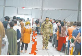  ?? David Goldman The Associated Press ?? Afghan refugees line up for food Sept. 10 at Fort Bliss’ Doña Ana Village in Chaparral, N.M. The Biden administra­tion notified governors and mayors this week of plans to resettle the first wave of the 65,000 Afghan evacuees.