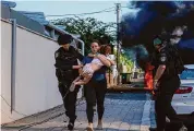  ?? Tsafrir Abayov/Associated Press ?? Police officers evacuate a woman and a child last month from a site in Ashkelon in southern Israel that was hit by a rocket.