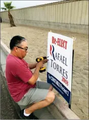  ?? LOANED PHOTO ?? RAFAEL TORRES, THE INCUMBENT CONSTABLE in San Luis seeking re-election, replaces a campaign sign that was stolen recently.