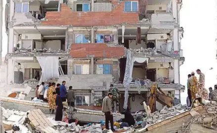  ?? REUTERS PIC ?? Victims of the earthquake looking for their belongings in Pole-Zahab in Kermanshah Province, Iran, on Monday.