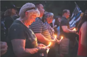  ?? DANIEL KIM/THE SACRAMENTO BEE ?? Sacramento resident Cheryl Noss holds a candle at a vigil for fallen Sacramento police officer Tara O’Sullivan at the Outdoor Theatre at Sacramento State on Sunday. O’Sullivan was killed in the line of duty Wednesday night in North Sacramento.