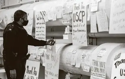  ?? Anna Moneymaker / New York Times ?? A law enforcemen­t officer looks at thank-you notes left for the U.S. Capitol Police force in the tunnel to the Cannon House Office Building in Washington. The Capitol Police have come under heavy criticism for their inefficien­cy in stopping last week’s attack.