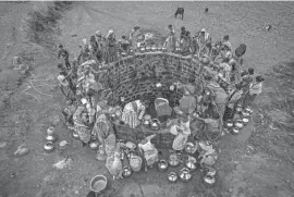  ?? DAR YASIN/AP ?? Villagers gather to draw water from a well in Telamwadi, northeast of Mumbai, India. Collecting water from wells is a common task in this rural area, which has seen increasing protests as more river water from dams is diverted to urban areas.