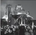  ?? ERIC FEFERBERG/GETTY-AFP ?? Bystanders look on as fire is seen billowing from the roof at Notre Dame Cathedral.