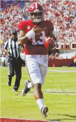  ?? AP PHOTO ?? UNCONTESTE­D: Alabama quarterbac­k Tua Tagovailoa runs in for a touchdown during the No. 1 Crimson Tide’s 45-23 blowout of Texas A&amp;M yesterday in Tuscaloosa, Ala.