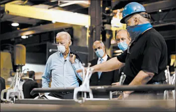  ?? MATT SLOCUM/AP ?? Democratic presidenti­al candidate and former Vice President Joe Biden listens to McGregor Industries fitter Michael Phillips during a tour Thursday of the facility in Dunmore, Pa.