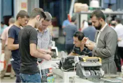  ?? — Reuters ?? A man counts money using a cash counting machine at a shop in Erbil, Iraq.