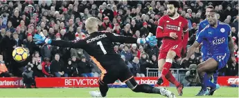  ??  ?? Liverpool’s Mohamed Salah, centre, scores his team’s second goal against Leicester City.