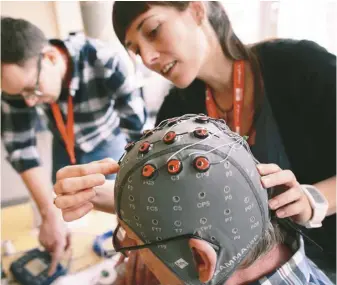  ?? ?? 在瑞士舉行的一場「腦機接口」研究會中，物理治療師正將電極放­置在患者的頭部。（Getty Images）